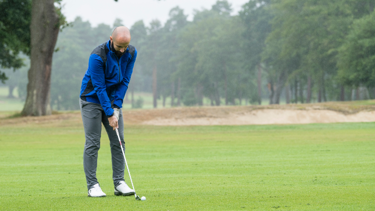 a-golfer-hitting-an-approach-shot-on-a-drizzly-fairway