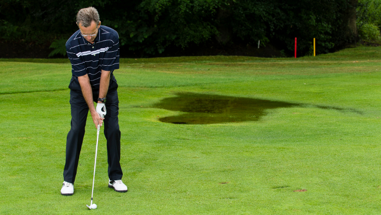 a-golfer-about-to-hit-a-wedge-shot-on-a-watery-fairway