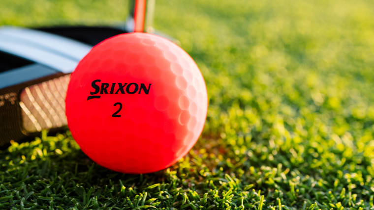 an-orange-srixon-soft-feel-golf-ball-resting-on-grass