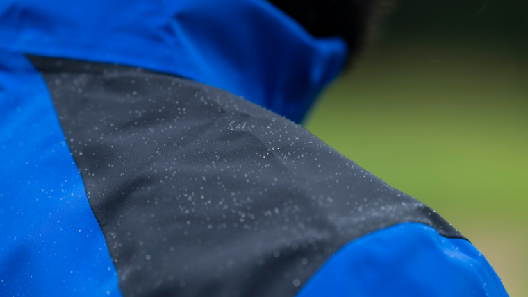 a-close-up-of-raindrops-on-a-golfer-wearing-a-waterproof-jacket