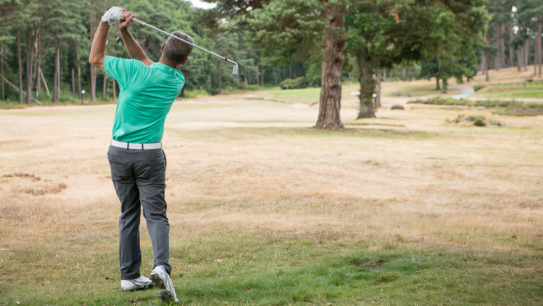 a-golfer-using-a-utility-iron-from-the-rough