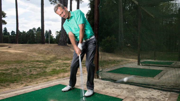 a-golfer-hitting-balls-in-a-practice-net