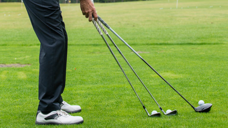 a-golfer-holding-multiple-golf-clubs