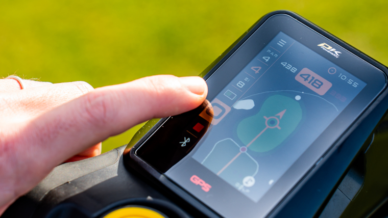 a-golfer-navigating-a-powakaddy-rx12-gps-electric-trolley-console