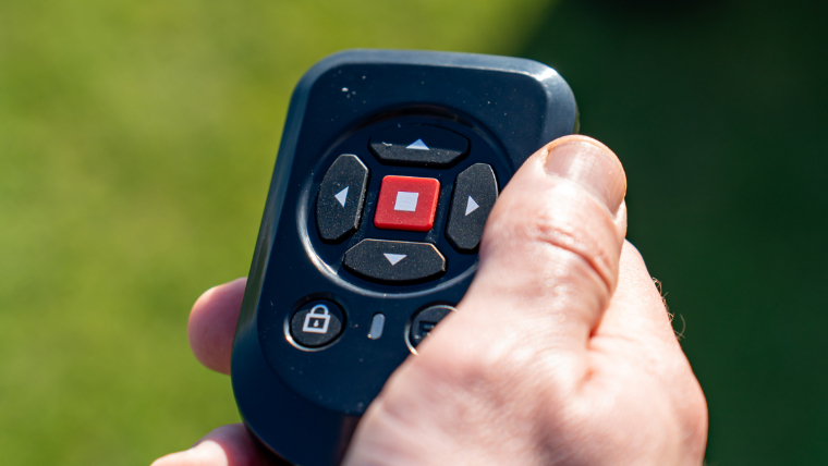 a-golfer-using-an-electric-trolley-remote-control
