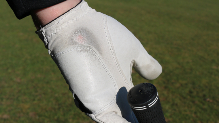 a-golf-glove-with-worn-patches-on-it