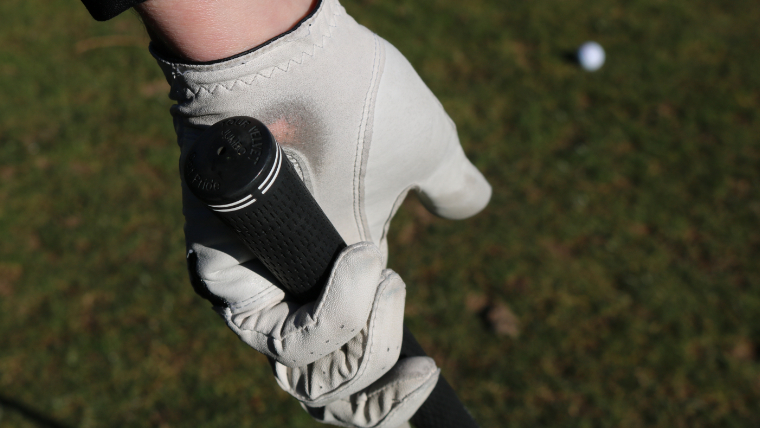 a-golfer-gripping-golf-glove-with-a-worn-glove