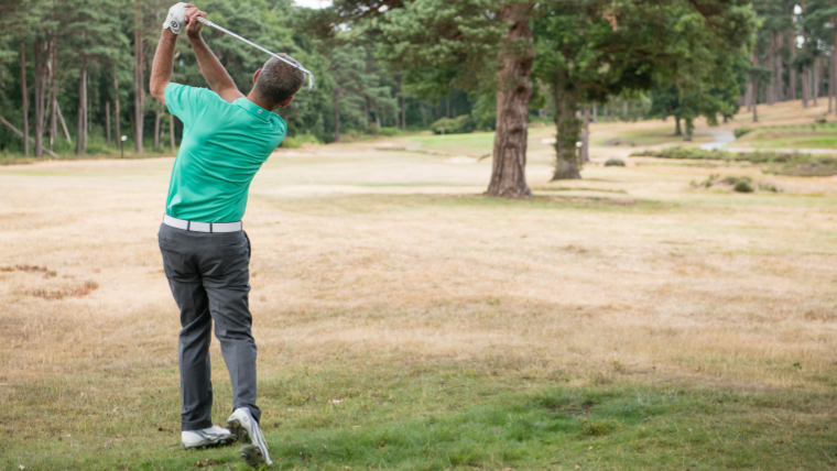 a-golfer-striking-an-iron-from-the-rough