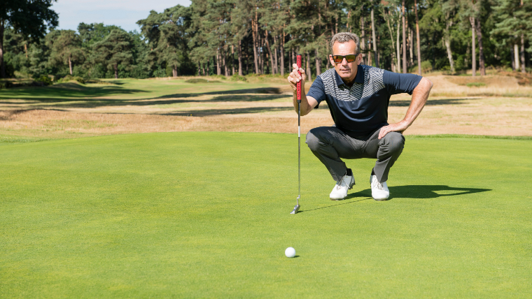 a-golfer-studying-the-line-of-a-putt-on-a-green