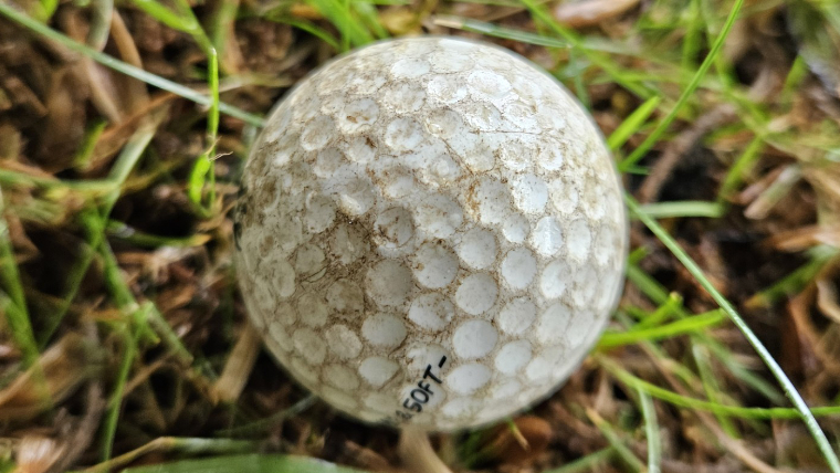 an-old-scuffed-golf-ball