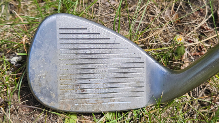 a-close-up-of-a-dirty-wedge-clubface