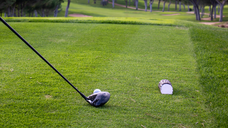 a-driver-at-address-behind-a-ball-on-a-tee
