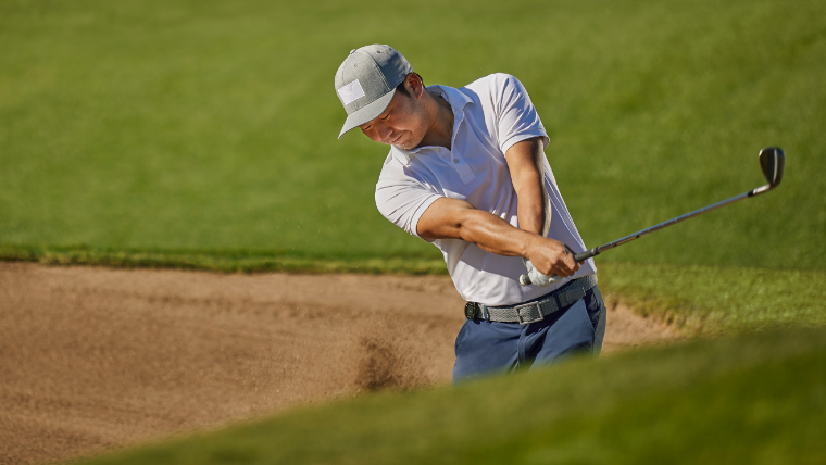 a-golfer-striking-a-bunker-shot