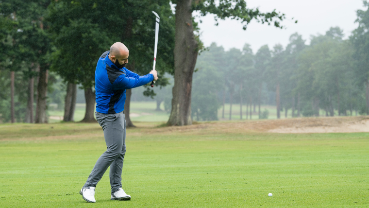 a-golfer-striking-a-ball-on-a-fairway