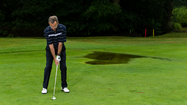 a-golfer-hitting-an-approach-shot-near-standing-water