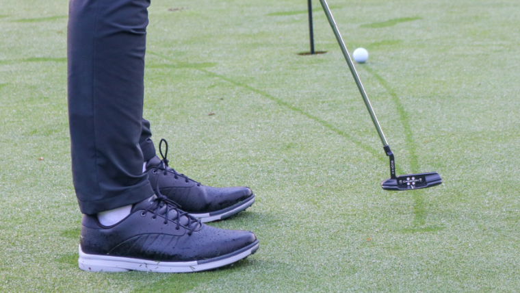 a-golfer-putting-on-a-green-wet-with-dew