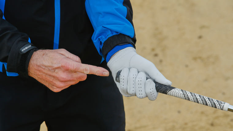 a-golfer-pointing-at-his-golf-glove