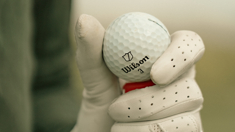a-golfer-holding-a-wilson-golf-ball