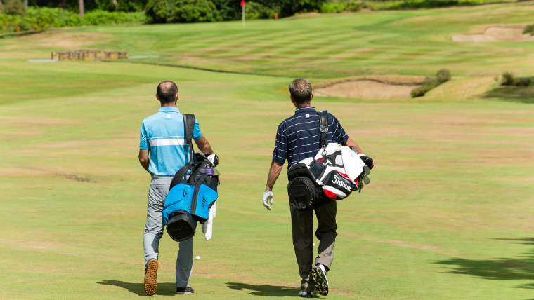 two-golfers-walking-along-a-fairway