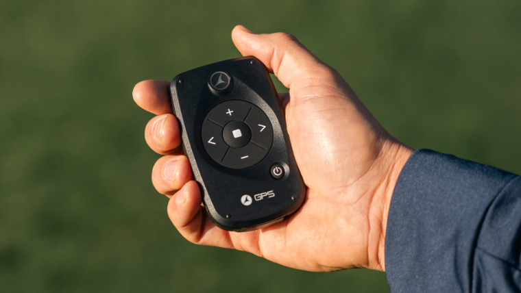 a-golfer-holding-a-motocaddy-remote-control-device