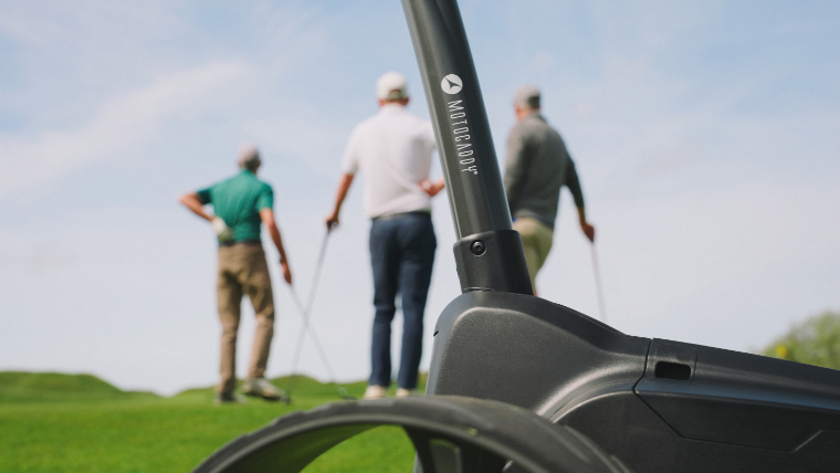 golfers-standing-beyond-a-motocaddy-trolley-frame