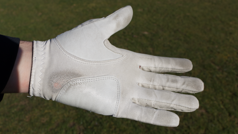 a-golf-glove-with-signs-of-wear-on-it